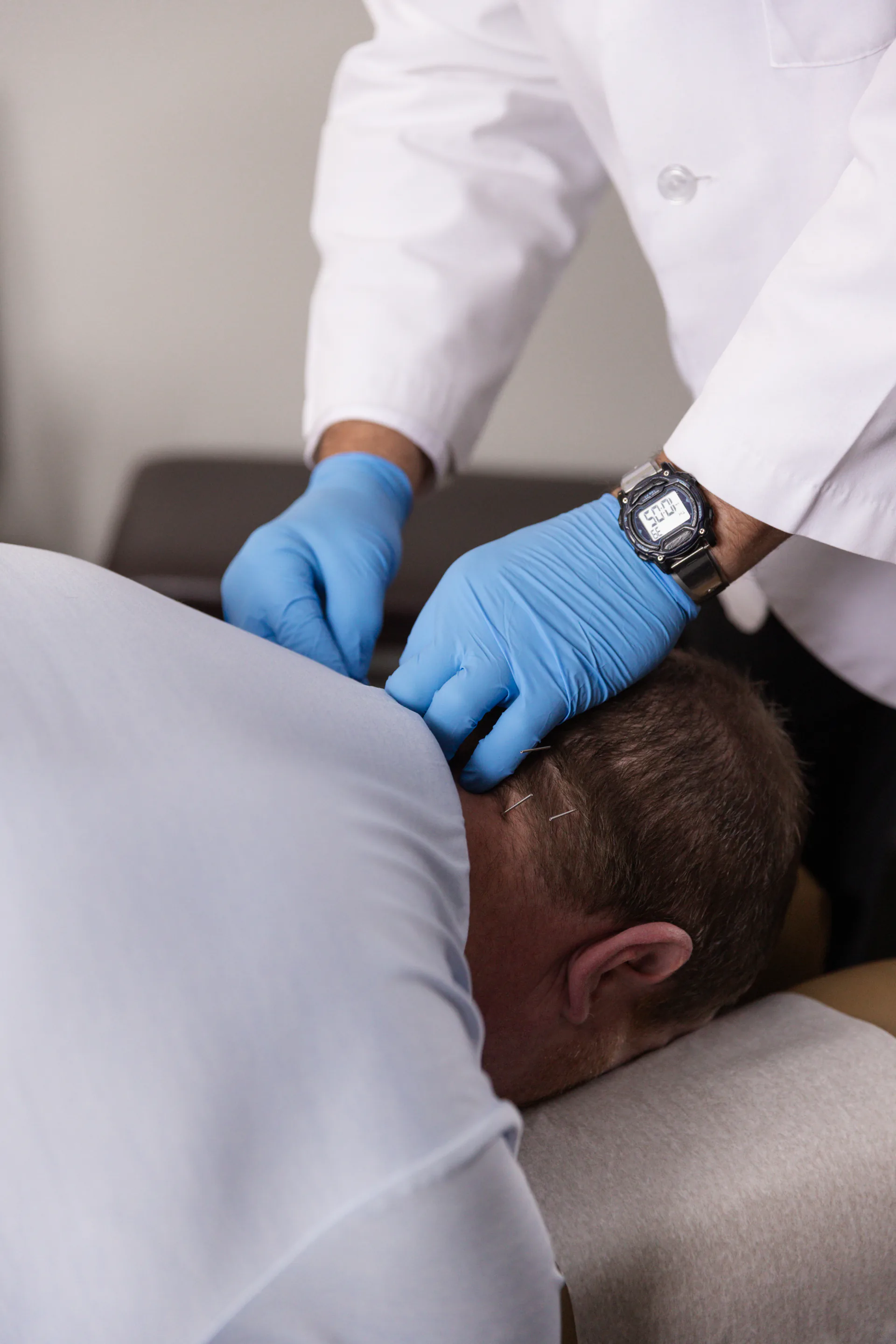 Provider performing dry needling treatment on a patient's shoulder